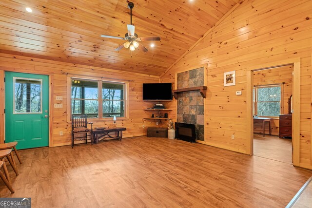 living area featuring wooden ceiling, wood walls, light wood-style floors, and ceiling fan