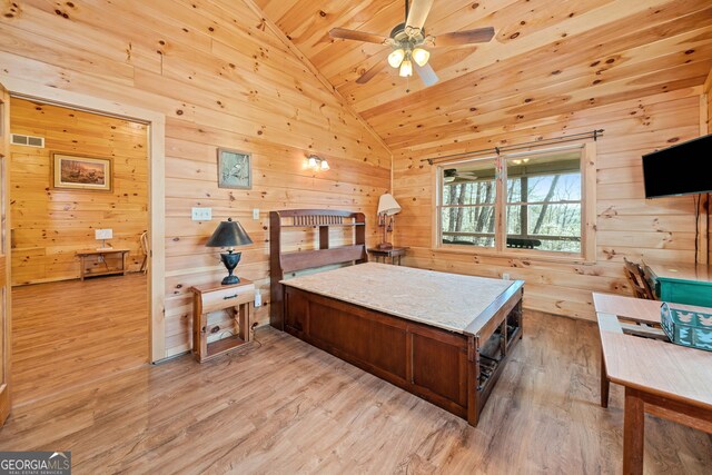 bedroom with vaulted ceiling, light wood-style floors, wood ceiling, wood walls, and visible vents