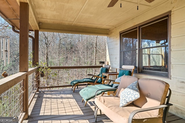 wooden terrace featuring a ceiling fan and a porch