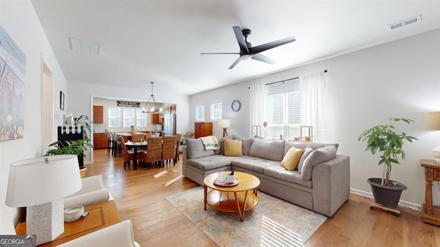 living room with light wood-type flooring and ceiling fan