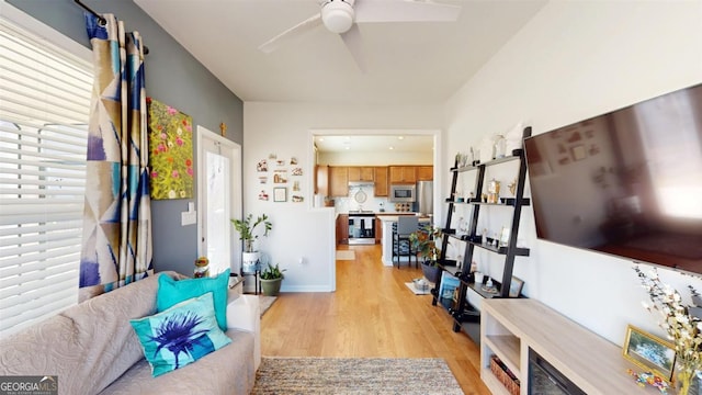 living room with light wood-type flooring and ceiling fan