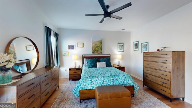 bedroom with light hardwood / wood-style flooring and ceiling fan