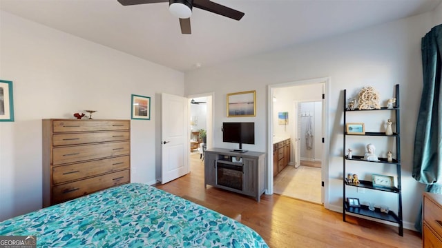 bedroom with ensuite bathroom and hardwood / wood-style floors