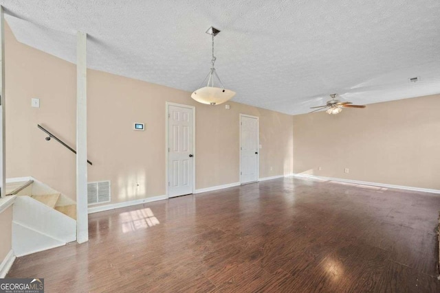 interior space featuring a textured ceiling, dark wood-type flooring, and ceiling fan