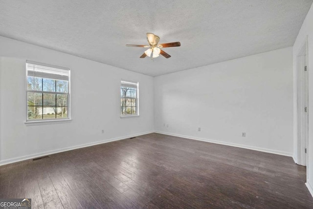 empty room with a textured ceiling, ceiling fan, and dark hardwood / wood-style floors