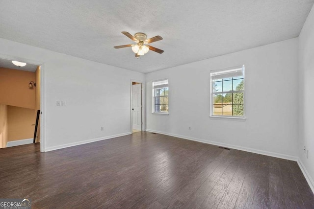 spare room featuring ceiling fan, dark wood-type flooring, and a textured ceiling