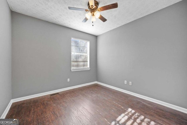 empty room featuring a textured ceiling, ceiling fan, and dark hardwood / wood-style floors