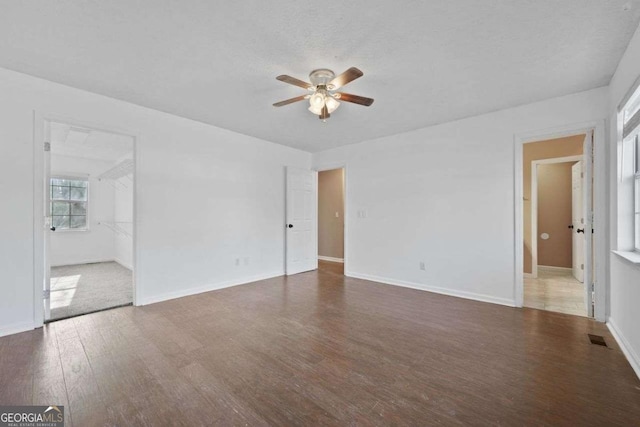 interior space featuring ceiling fan, a textured ceiling, and dark hardwood / wood-style flooring