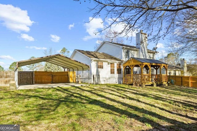 back of house featuring a yard, a wooden deck, a gazebo, and a carport