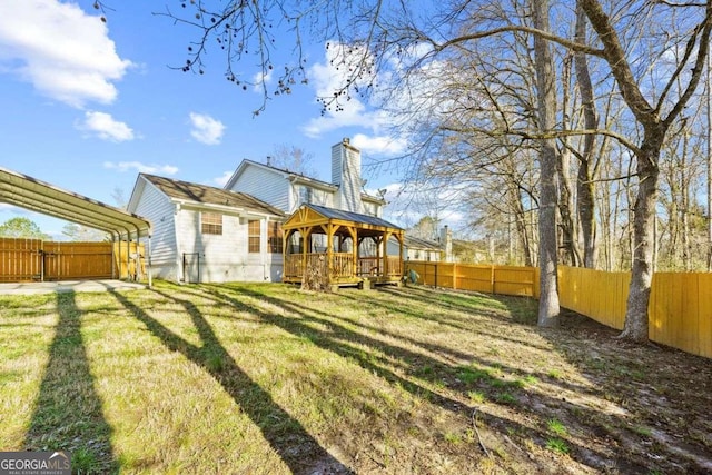 back of property featuring a yard, a wooden deck, and a gazebo