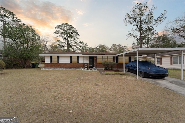 view of front of property with a yard and a carport