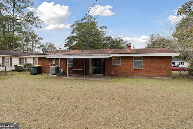 rear view of house with cooling unit, a lawn, and a patio area