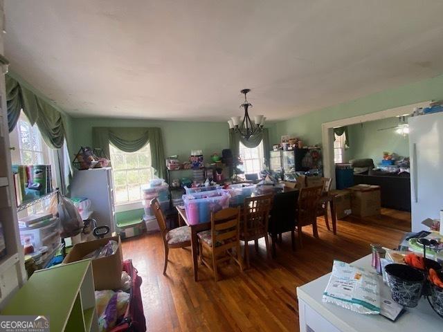 dining area with hardwood / wood-style flooring and a notable chandelier