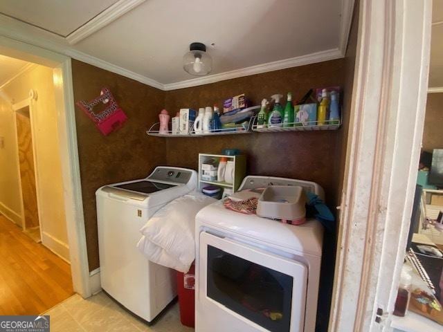 laundry room with crown molding and washing machine and clothes dryer