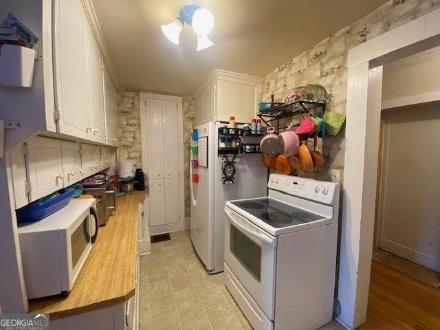 kitchen with white appliances and white cabinets