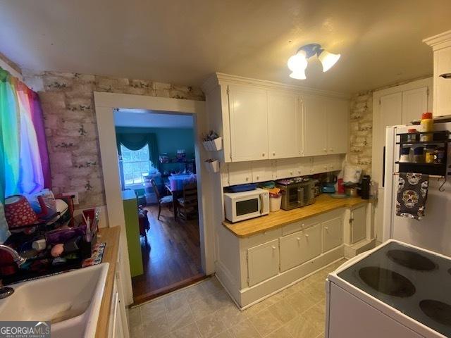 kitchen featuring white appliances, sink, and white cabinets