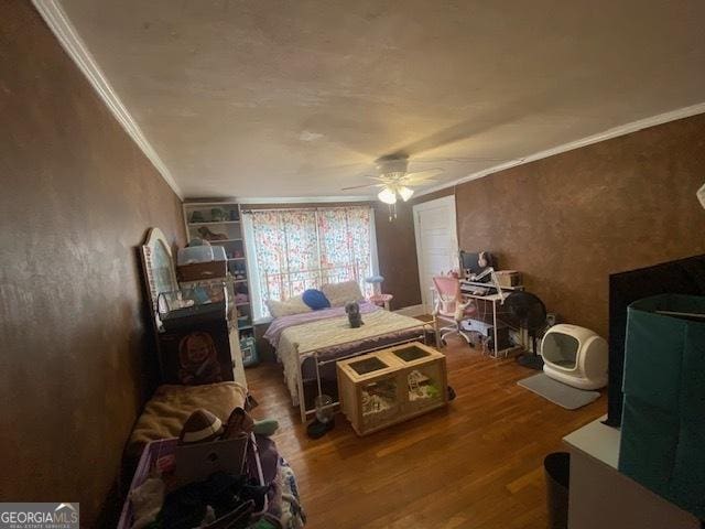 bedroom with ceiling fan, wood-type flooring, and ornamental molding