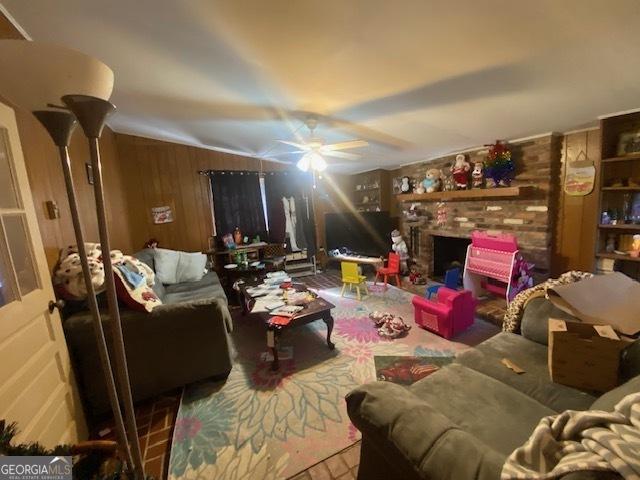 living room featuring wood walls and ceiling fan