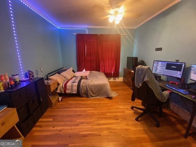 bedroom with light wood-type flooring, crown molding, and ceiling fan