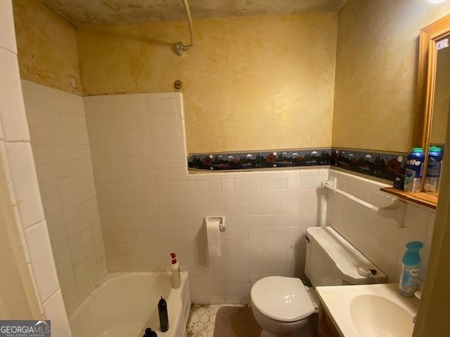 full bathroom with tile walls, vanity, toilet, and bathtub / shower combination