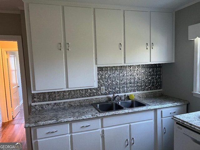 kitchen featuring dishwasher, white cabinets, and a sink