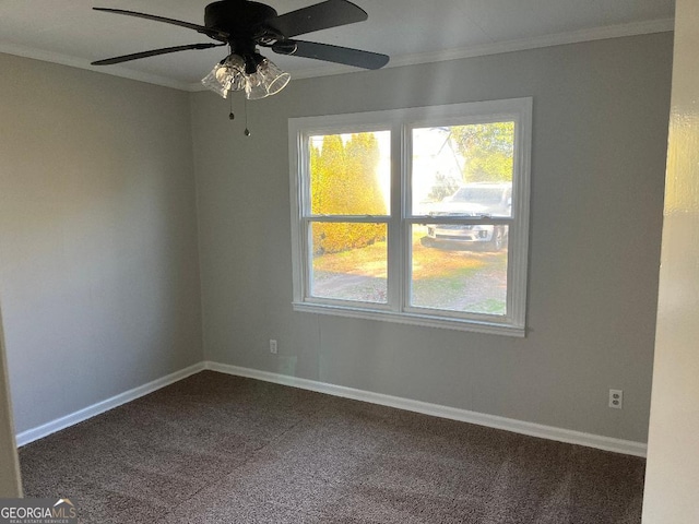 unfurnished room featuring a healthy amount of sunlight, baseboards, dark colored carpet, and crown molding