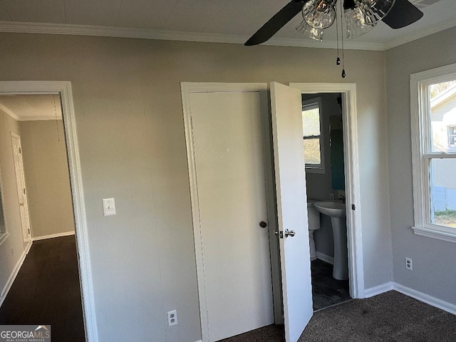 unfurnished bedroom with multiple windows, crown molding, baseboards, and ceiling fan