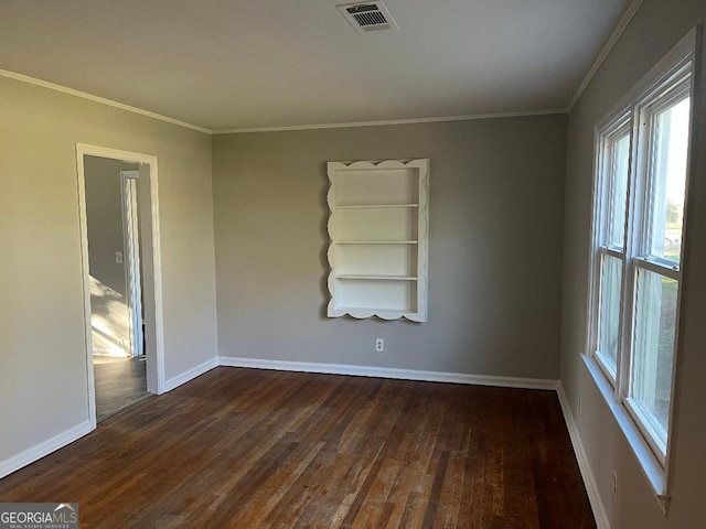 unfurnished room with dark wood-type flooring, visible vents, ornamental molding, and baseboards