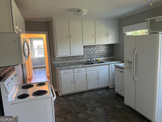 kitchen with white appliances, white cabinets, and a sink