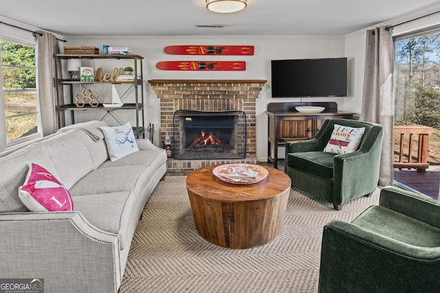 living room featuring a brick fireplace and crown molding