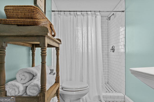 bathroom with sink, toilet, and curtained shower