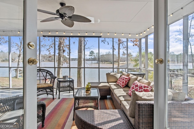 sunroom featuring a water view, ceiling fan, and track lighting