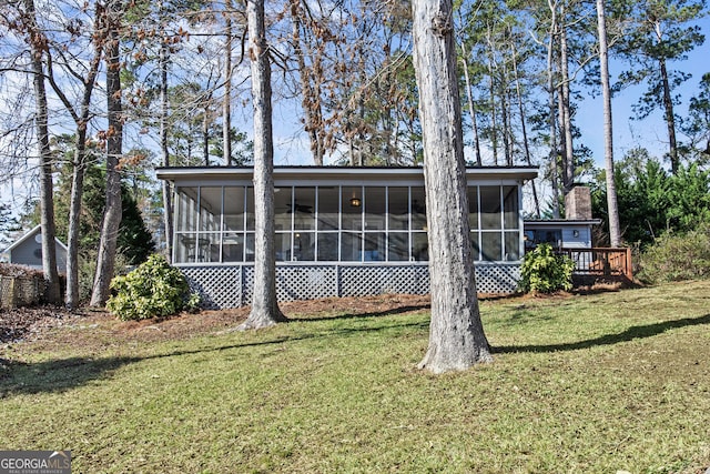 back of house with a yard and a sunroom