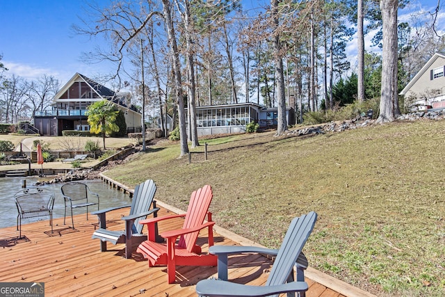 wooden deck featuring a water view and a lawn