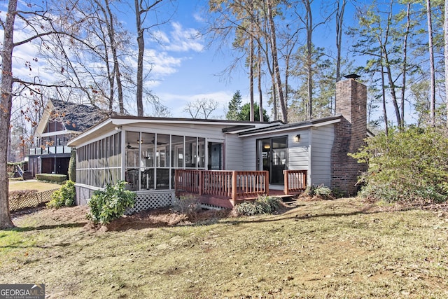 rear view of house featuring a yard and a sunroom