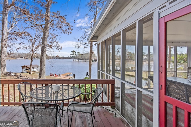 wooden terrace featuring a water view and a sunroom