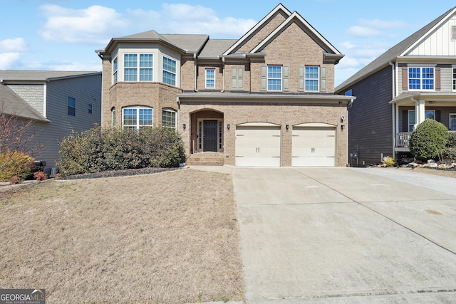 view of front of property featuring a garage, concrete driveway, and brick siding