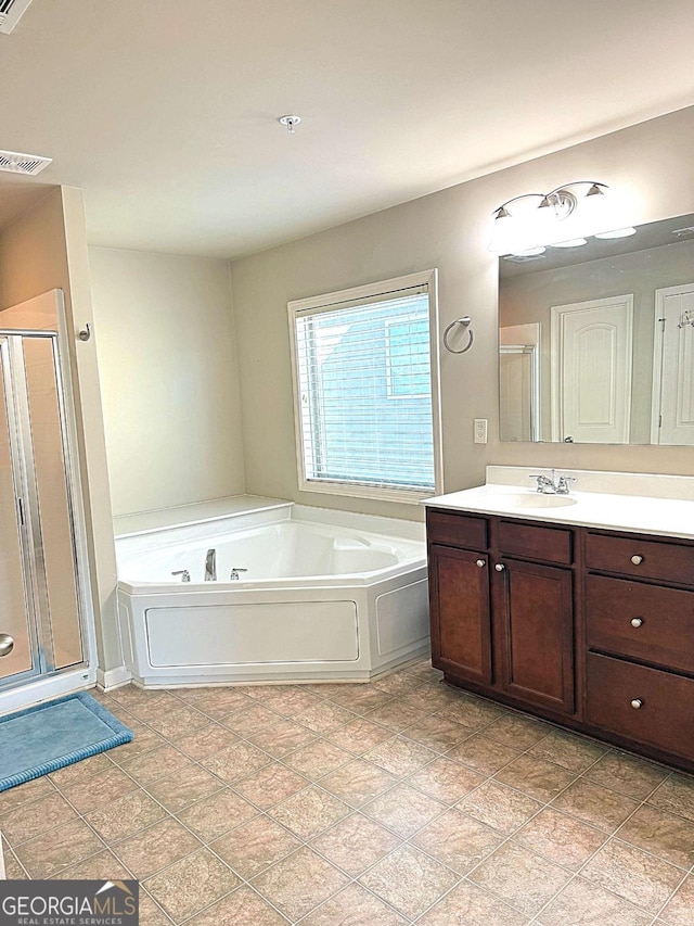 bathroom with vanity and shower with separate bathtub