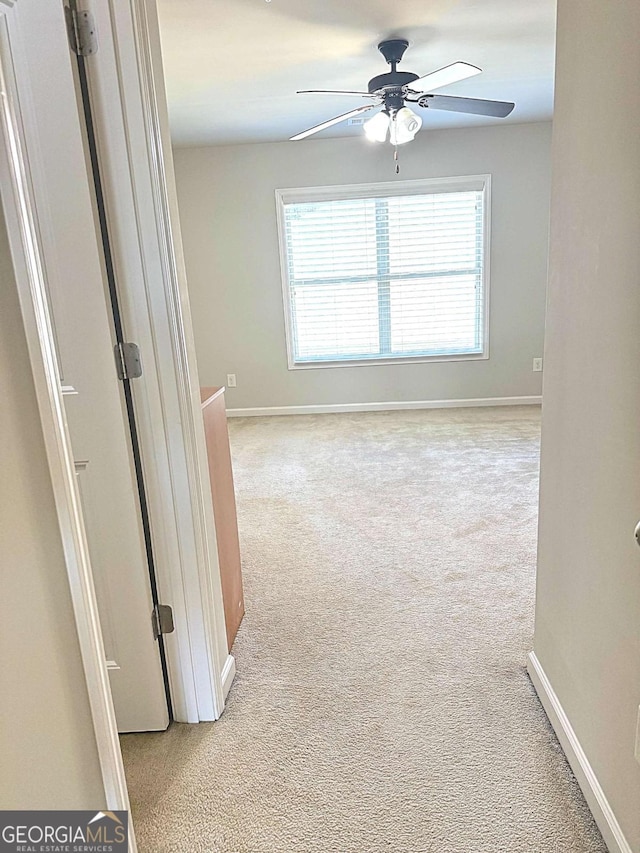 empty room featuring light carpet and ceiling fan