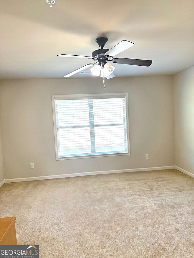 carpeted spare room featuring ceiling fan