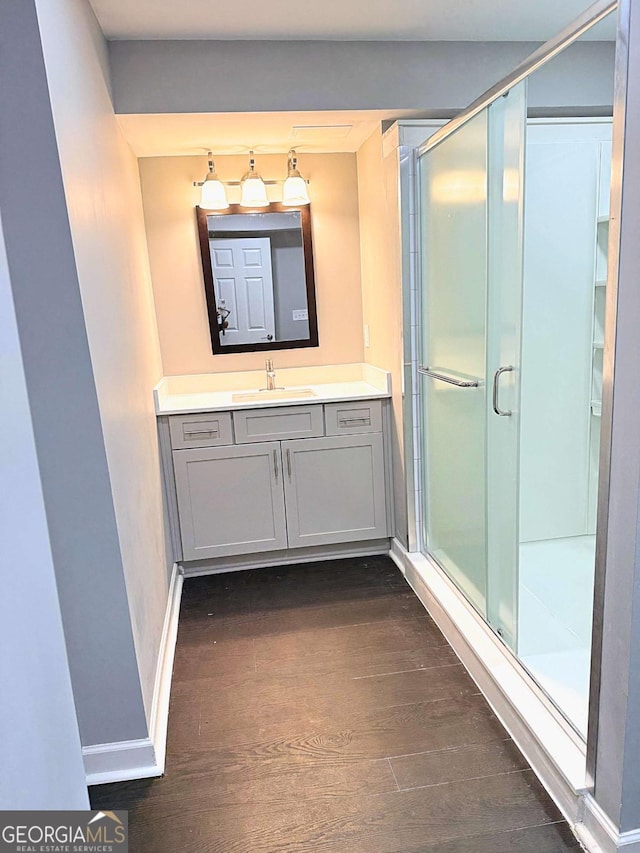 bathroom with vanity, hardwood / wood-style floors, and a shower with shower door