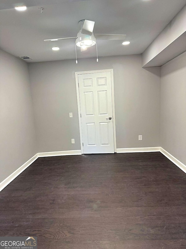 basement featuring ceiling fan and dark hardwood / wood-style flooring