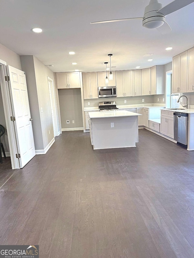 kitchen featuring white cabinets, hanging light fixtures, stainless steel appliances, and a kitchen island