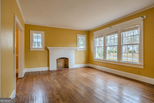 unfurnished living room with a wealth of natural light, crown molding, hardwood / wood-style flooring, and a fireplace