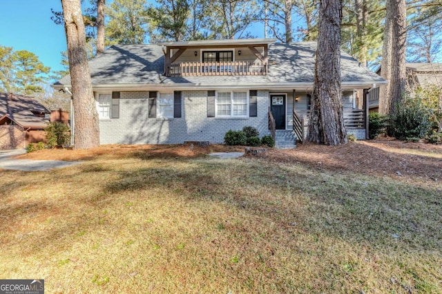 view of front of house featuring a balcony and a front yard