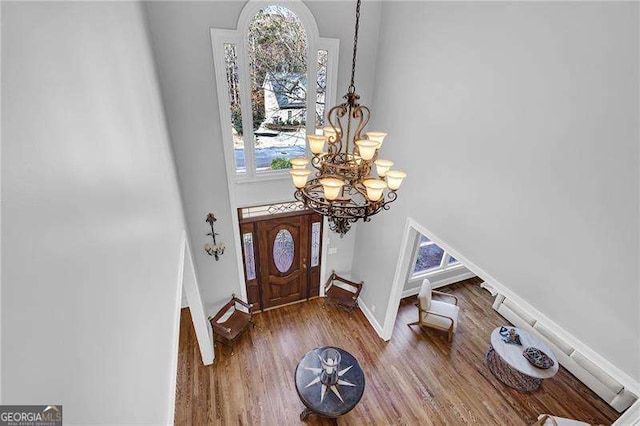 foyer featuring a high ceiling, hardwood / wood-style floors, and a chandelier