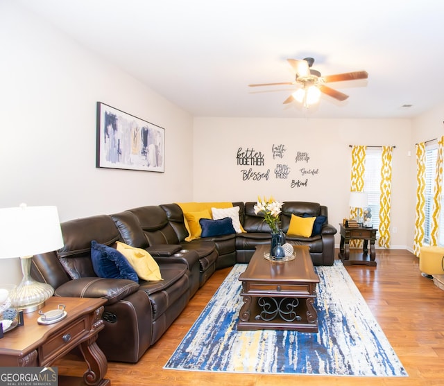 living area featuring a ceiling fan and wood finished floors