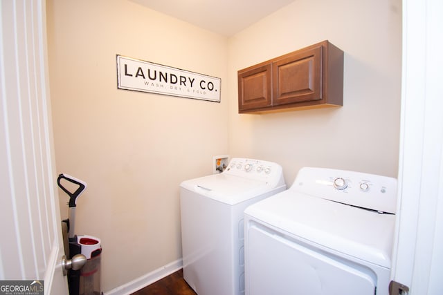 washroom featuring washing machine and clothes dryer, cabinet space, and baseboards