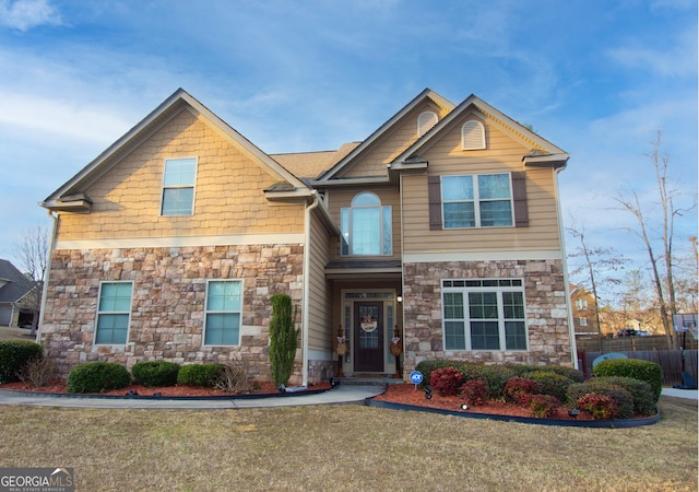 craftsman-style house featuring a front yard and fence