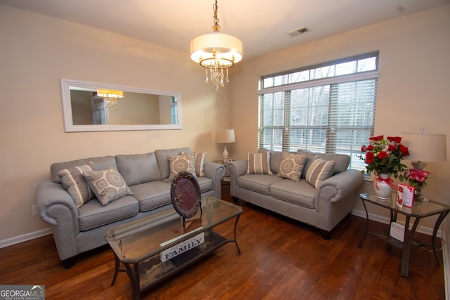 living area with a notable chandelier, dark wood-type flooring, visible vents, and baseboards